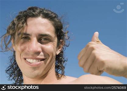 Portrait of a mid adult man giving a thumbs up sign