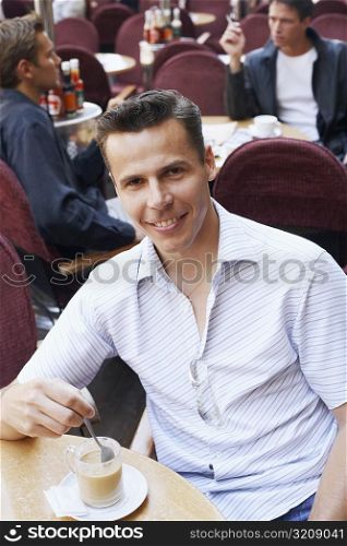Portrait of a mid adult man having tea in a restaurant