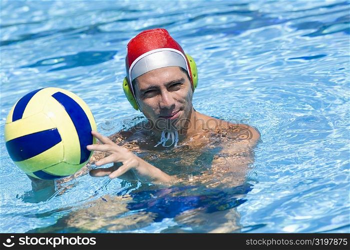 Portrait of a mid adult man holding a ball in a swimming pool