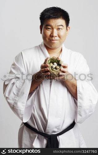 Portrait of a mid adult man holding a bird&acute;s nest
