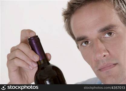 Portrait of a mid adult man holding a bottle of red wine