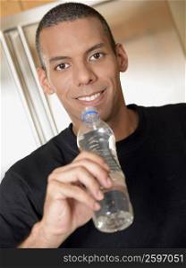 Portrait of a mid adult man holding a bottle of water and smiling