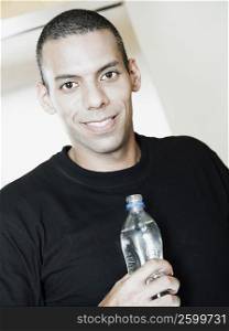Portrait of a mid adult man holding a bottle of water and smiling