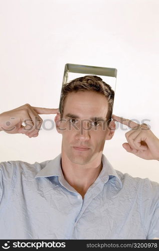 Portrait of a mid adult man holding a CD case on his head