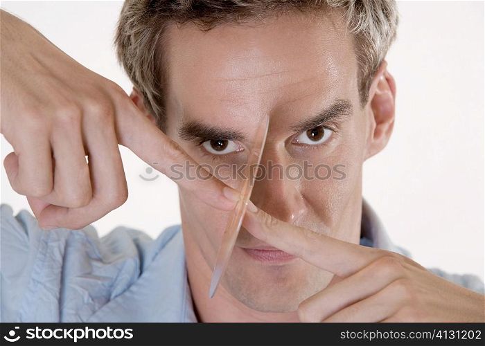 Portrait of a mid adult man holding a CD in front of his face