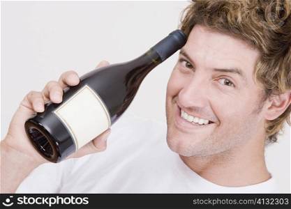 Portrait of a mid adult man holding a champagne bottle and smiling