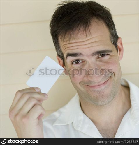 Portrait of a mid adult man holding a credit card and smiling