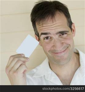 Portrait of a mid adult man holding a credit card and smiling
