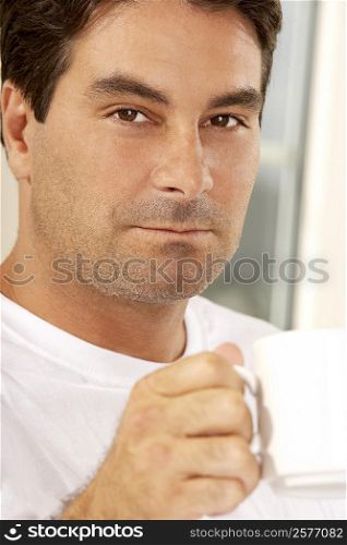 Portrait of a mid adult man holding a cup of coffee