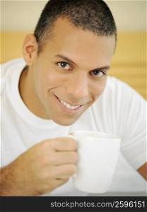Portrait of a mid adult man holding a cup of tea and smiling