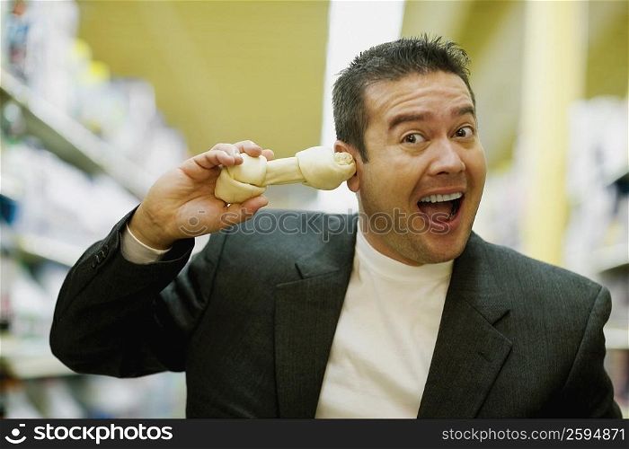Portrait of a mid adult man holding a dog bone and shouting
