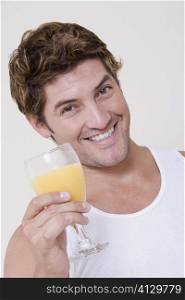 Portrait of a mid adult man holding a glass of orange juice