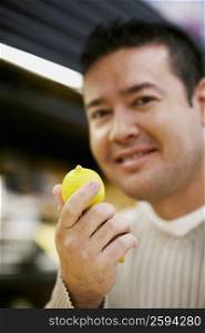 Portrait of a mid adult man holding a lemon