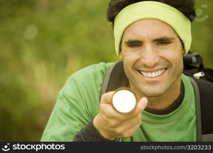 Portrait of a mid adult man holding a lit flashlight