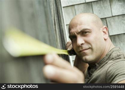 Portrait of a mid adult man holding a measuring tape