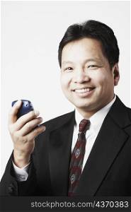 Portrait of a mid adult man holding a mobile phone smiling