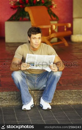 Portrait of a mid adult man holding a newspaper