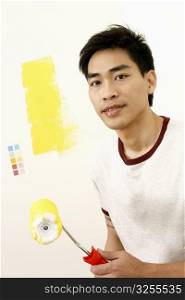 Portrait of a mid adult man holding a paint roller