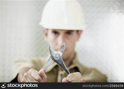 Portrait of a mid adult man holding a pair of pliers