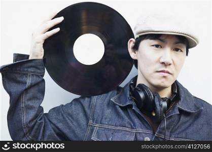 Portrait of a mid adult man holding a record on his shoulder