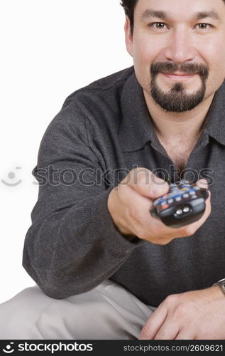 Portrait of a mid adult man holding a remote control and smirking