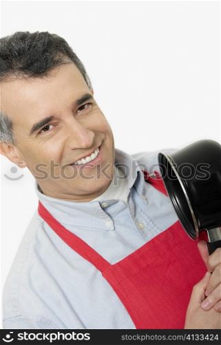 Portrait of a mid adult man holding a saucepan