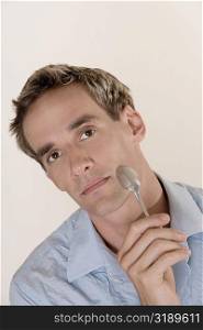 Portrait of a mid adult man holding a spoon