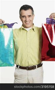 Portrait of a mid adult man holding shopping bags