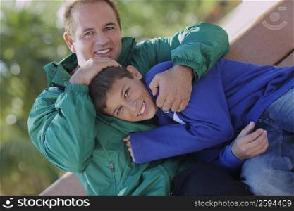 Portrait of a mid adult man hugging his son