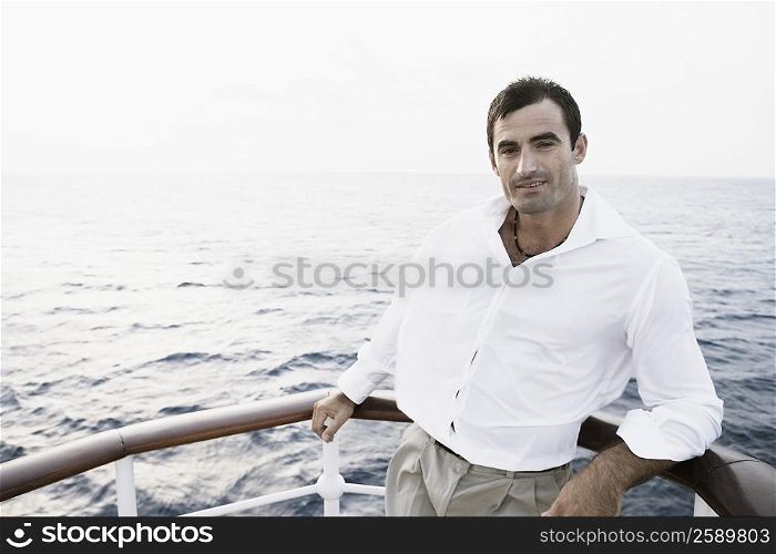Portrait of a mid adult man leaning against the railing of a boat