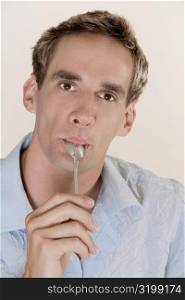 Portrait of a mid adult man licking a teaspoon