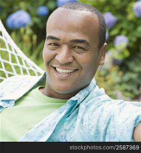 Portrait of a mid adult man lying in a hammock and smiling