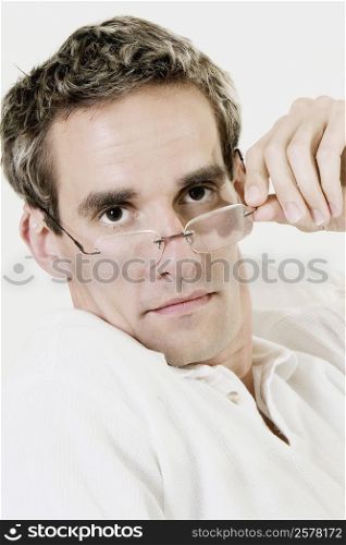 Portrait of a mid adult man peeking over his eyeglasses