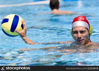Portrait of a mid adult man playing water polo in a swimming pool