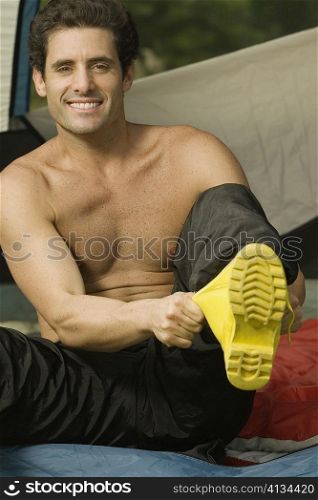 Portrait of a mid adult man putting on boots