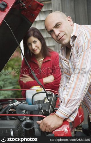Portrait of a mid adult man repairing a jeep