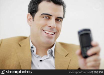 Portrait of a mid adult man showing a mobile phone and smiling