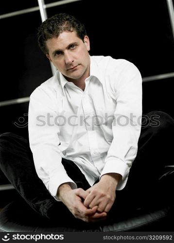 Portrait of a mid adult man sitting and holding his feet
