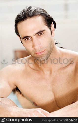 Portrait of a mid adult man sitting at the poolside