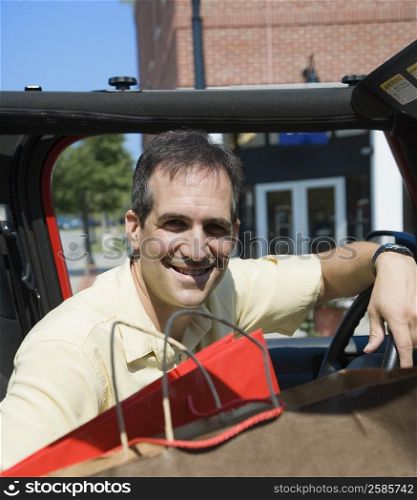 Portrait of a Mid adult man sitting in a car and smiling