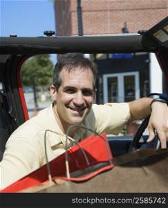 Portrait of a Mid adult man sitting in a car and smiling