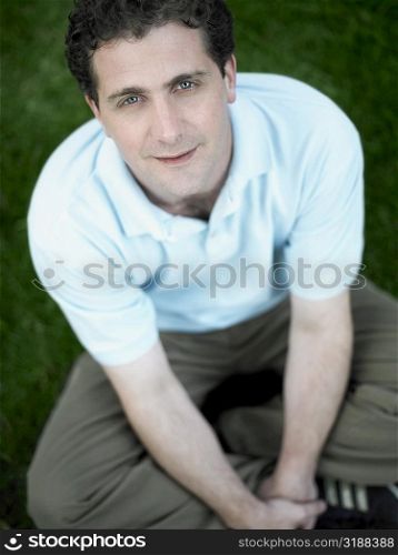 Portrait of a mid adult man sitting in a park and smiling