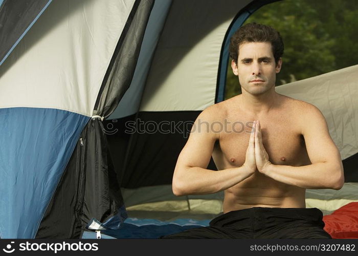 Portrait of a mid adult man sitting in a prayer position