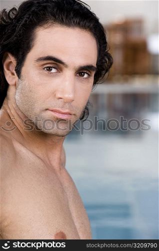 Portrait of a mid adult man sitting near a swimming pool