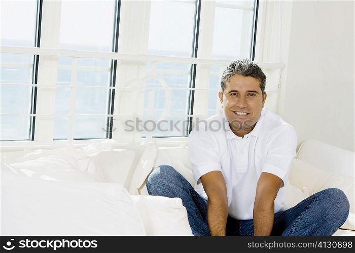 Portrait of a mid adult man sitting on a bed
