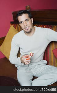Portrait of a mid adult man sitting on a couch and holding a cocktail