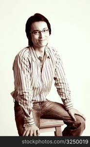 Portrait of a mid adult man sitting on a stool and smiling