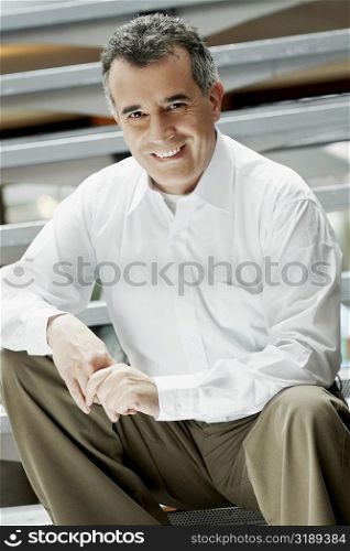 Portrait of a mid adult man sitting on steps