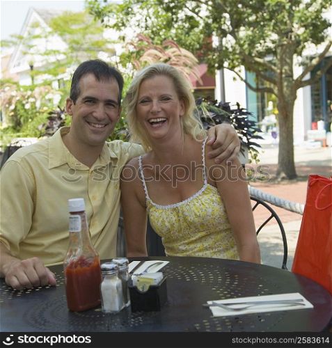 Portrait of a mid adult man sitting with a mature woman in a cafe and smiling