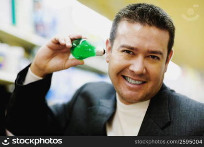 Portrait of a mid adult man smiling and holding a light bulb